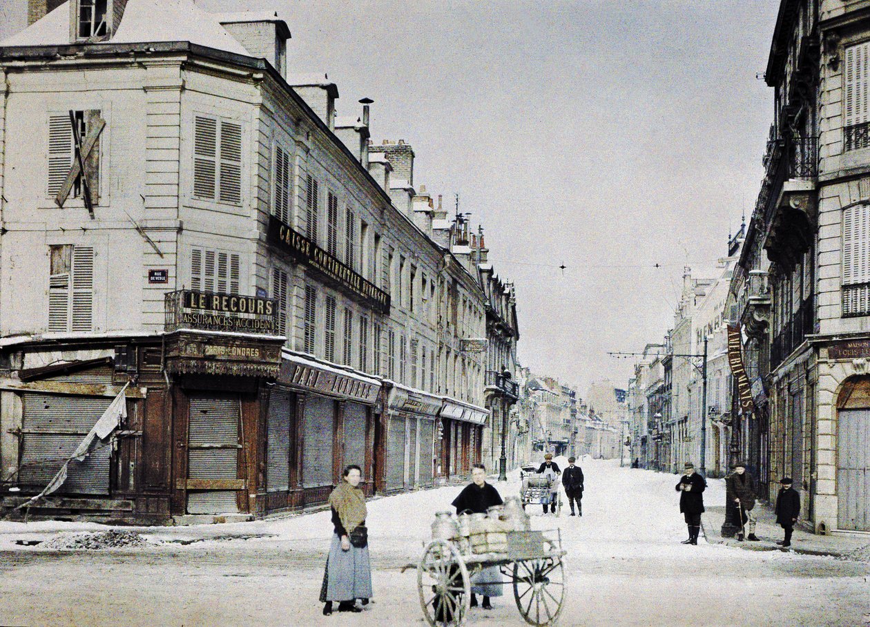 Žena s vozíkem naplněným plechovkami mléka v Rue de Vesle a muž s dalším vozíkem v Rue de Talleyrand za ní, Remeš, Francie, 3. března 1917 (autochrom) od Paul Castelnau