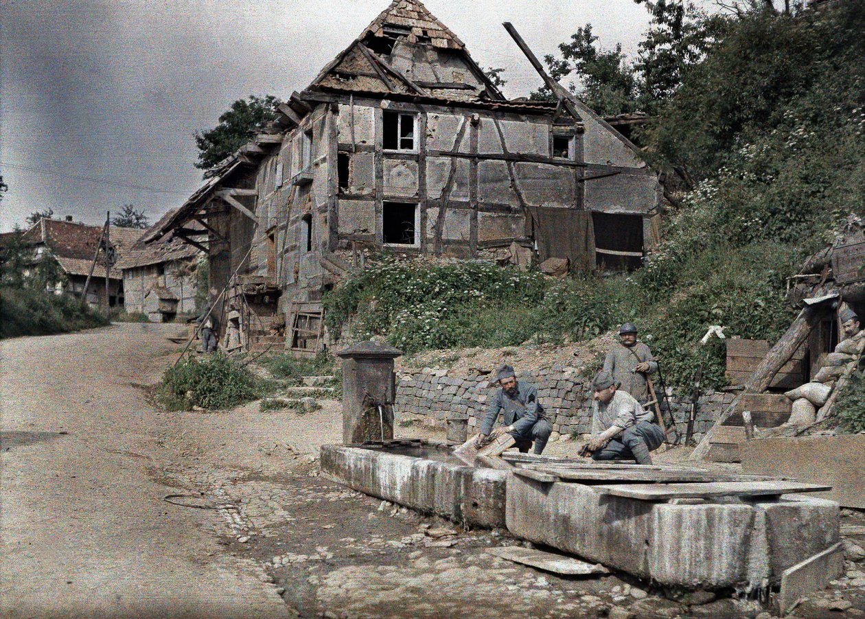 Dva francouzští vojáci přidělení k telefonní stanici praní prádla ve žlabu, Largitzen, department Haut-Rhin, Alsasko, Francie, 18. června 1917 (autochrom) od Paul Castelnau
