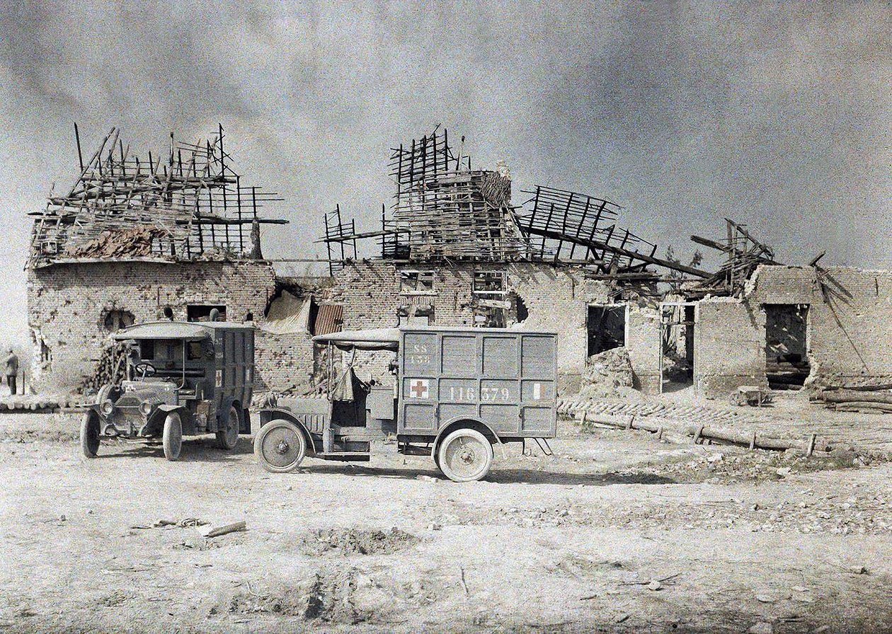 Dvě sanitní vozidla před budovou, která byla zdevastována dělostřeleckou palbou, Belgie, 17. září 1917 (autochrom) od Paul Castelnau
