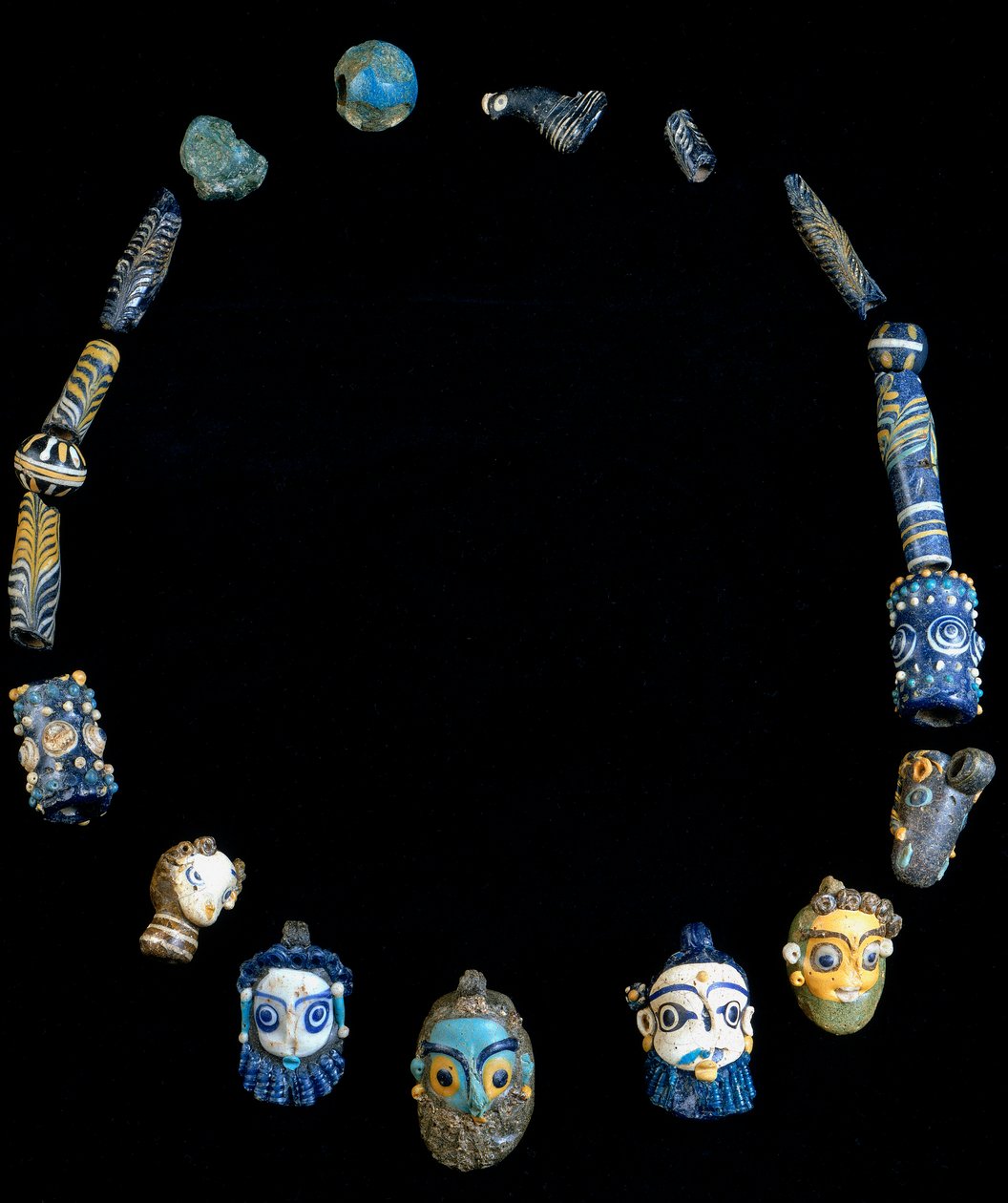 Náhrdelník ze skleněné pasty s přívěsky znázorňujícími vousaté hlavy, původně z Olbie, nyní konzervovaný v Národním archeologickém muzeu v Cagliari od Phoenician Phoenician