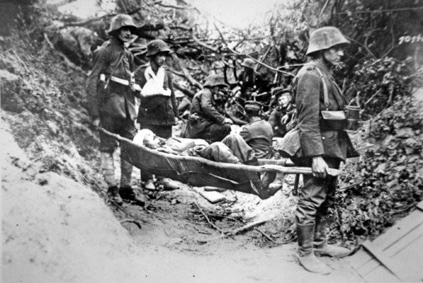 Němečtí vojáci z první světové války nesoucí zraněného spolubojovníka v improvizovaných nosítkách, poblíž Soissons, červen 1918 (č/b foto) od Photographer German
