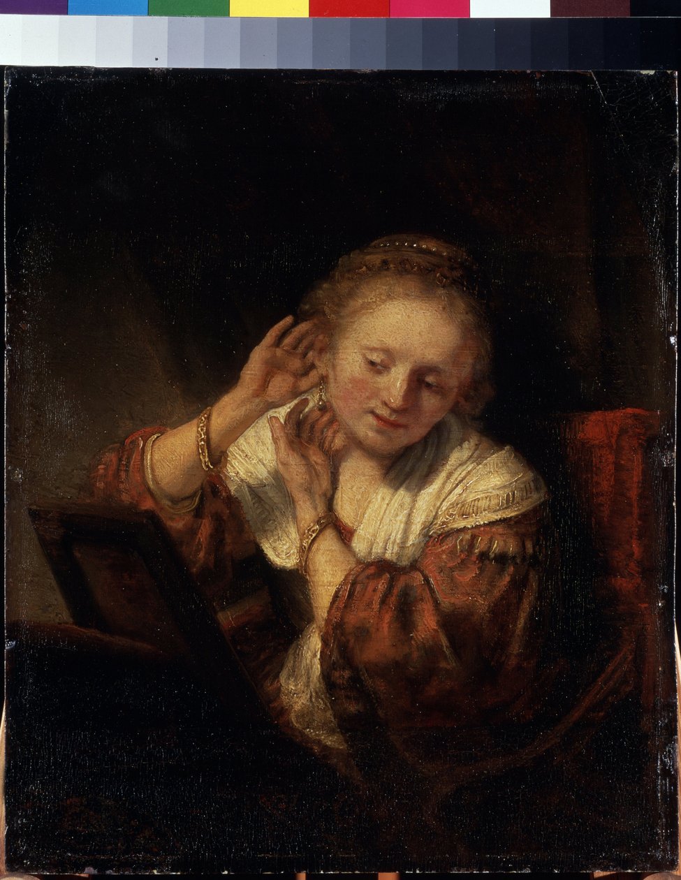 Mladá žena se snaží na náušnice. Mladá žena se snaží na náušnice. Obraz Harmenszoona van Rijna známý jako Rembrandt (1606-1669) od Rembrandt Harmensz. van Rijn