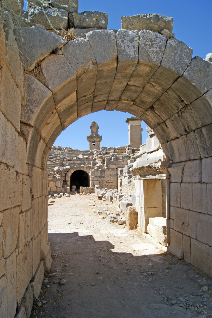 Pohled přes klenutý vchod divadla Xanthos do jámy orchestru, zobrazující sloup a hrobku Harpyje, Xanthos, Turecko (foto) od Roman