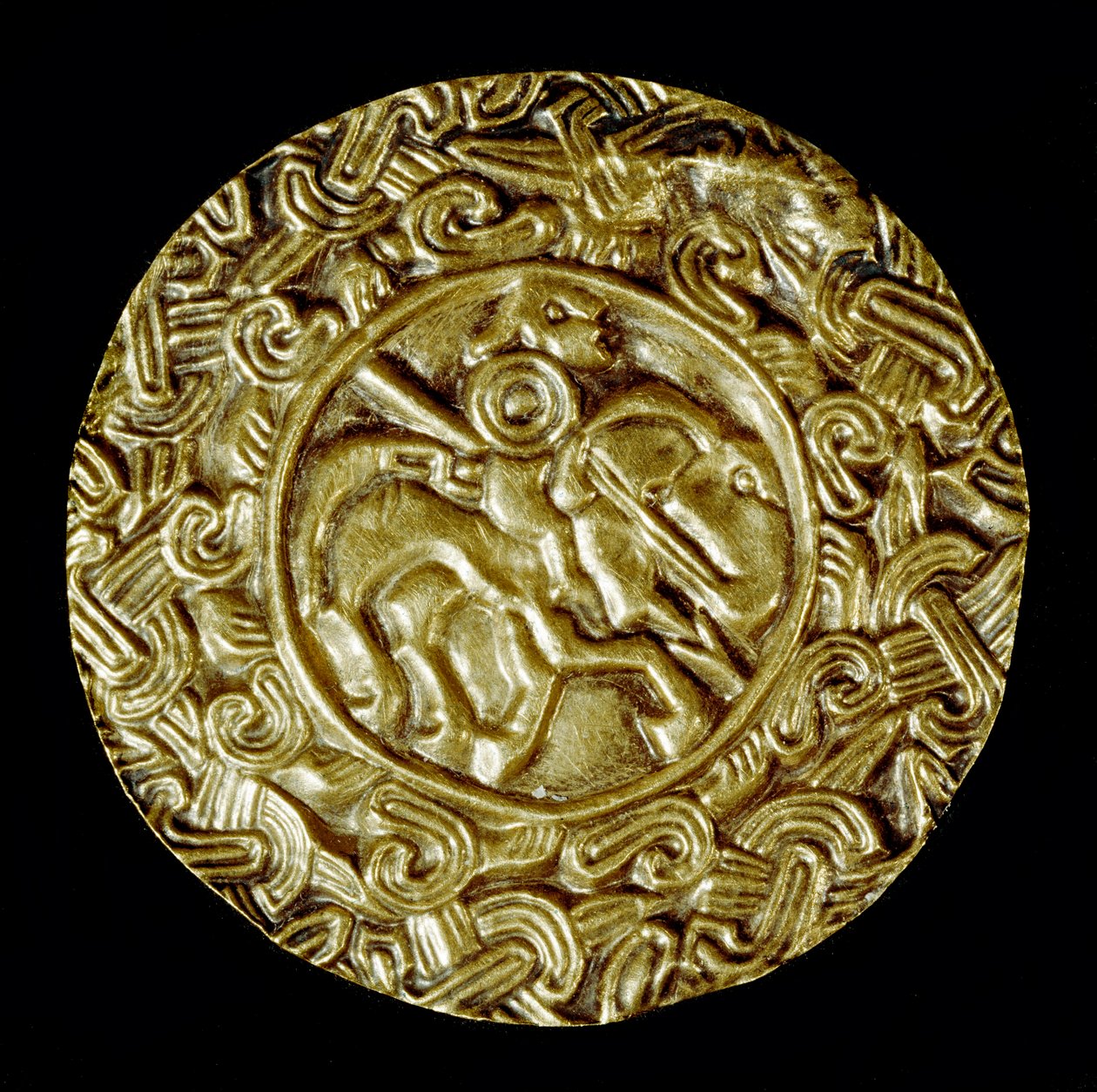 Archeologie středověku (středověk). Barbarské umění Lombardie: zlatý kotouč. Uprostřed je světec na koni s kopím a kolem zvířecích motivů. Lombardské umění, kolem 600. Rozměr: 47 cm Itálie, Cividale del Friuli, Archeologické muzeum od School Lombard