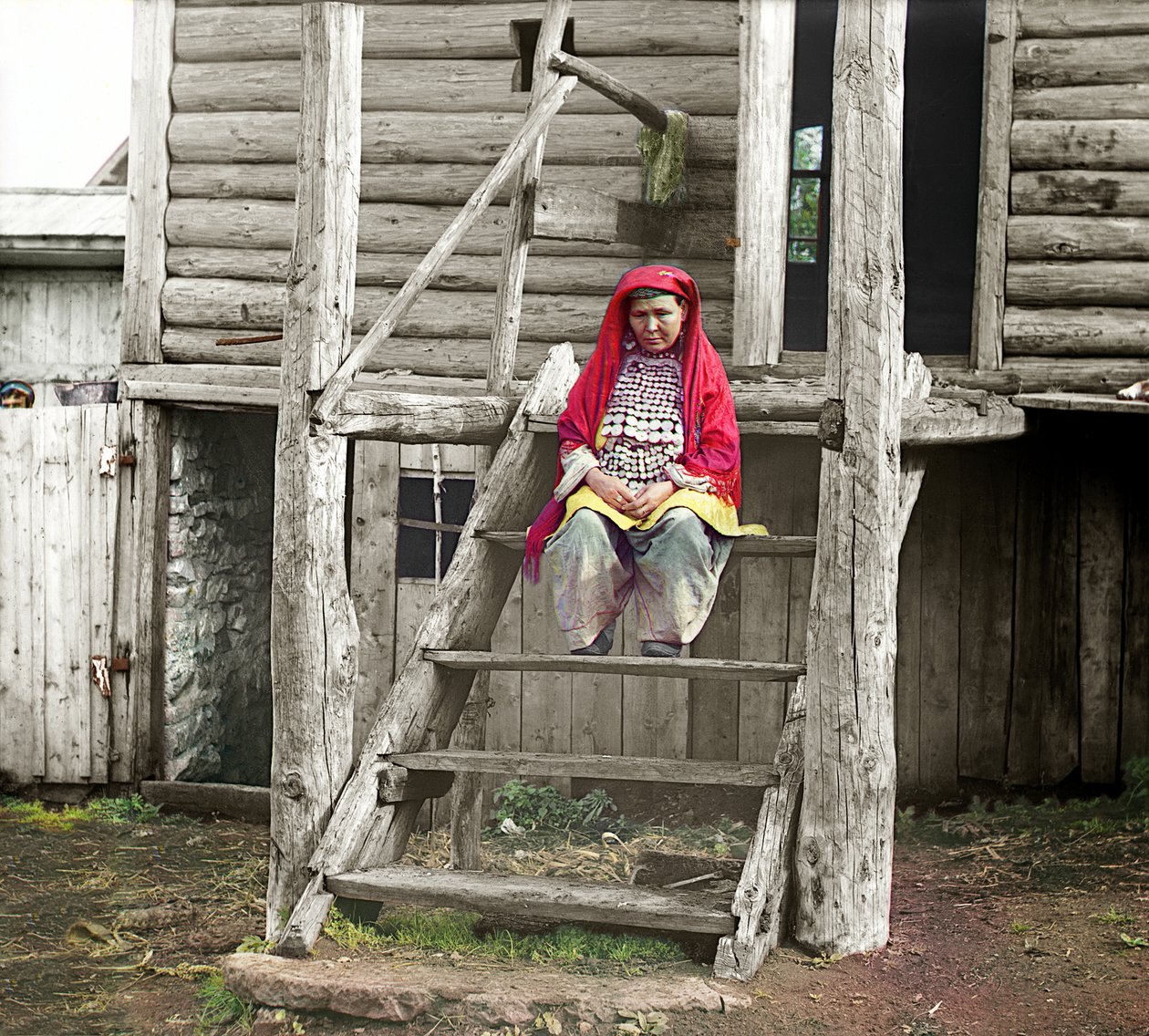 Baškirská žena v lidovém kroji sedící na schodech svého dřevěného domu, pohoří Ural, Ruská říše, 1910 od Sergey Prokudin Gorsky