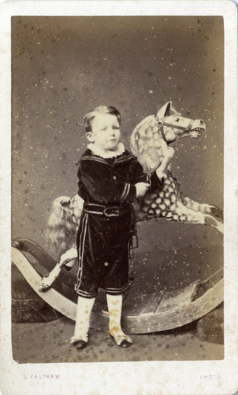 Chlapec stojící u houpacího koně od Silas Eastham