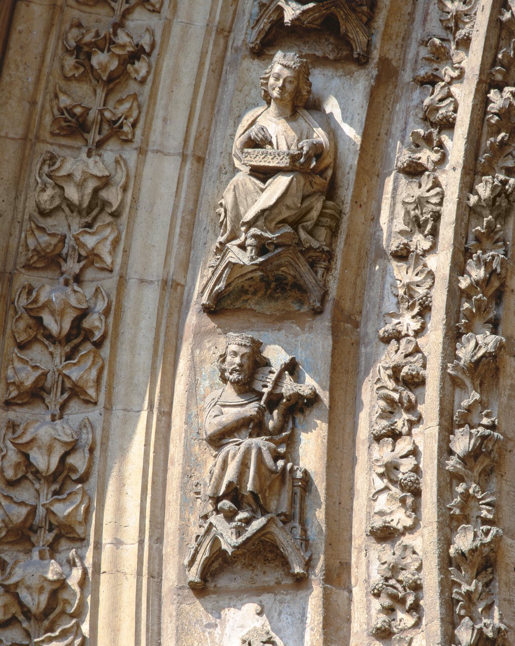 Archivolta středního portálu západního průčelí, detail houslisty a hráče na citeru, ca. 1350-1400 (vysoký reliéf) od Spanish School