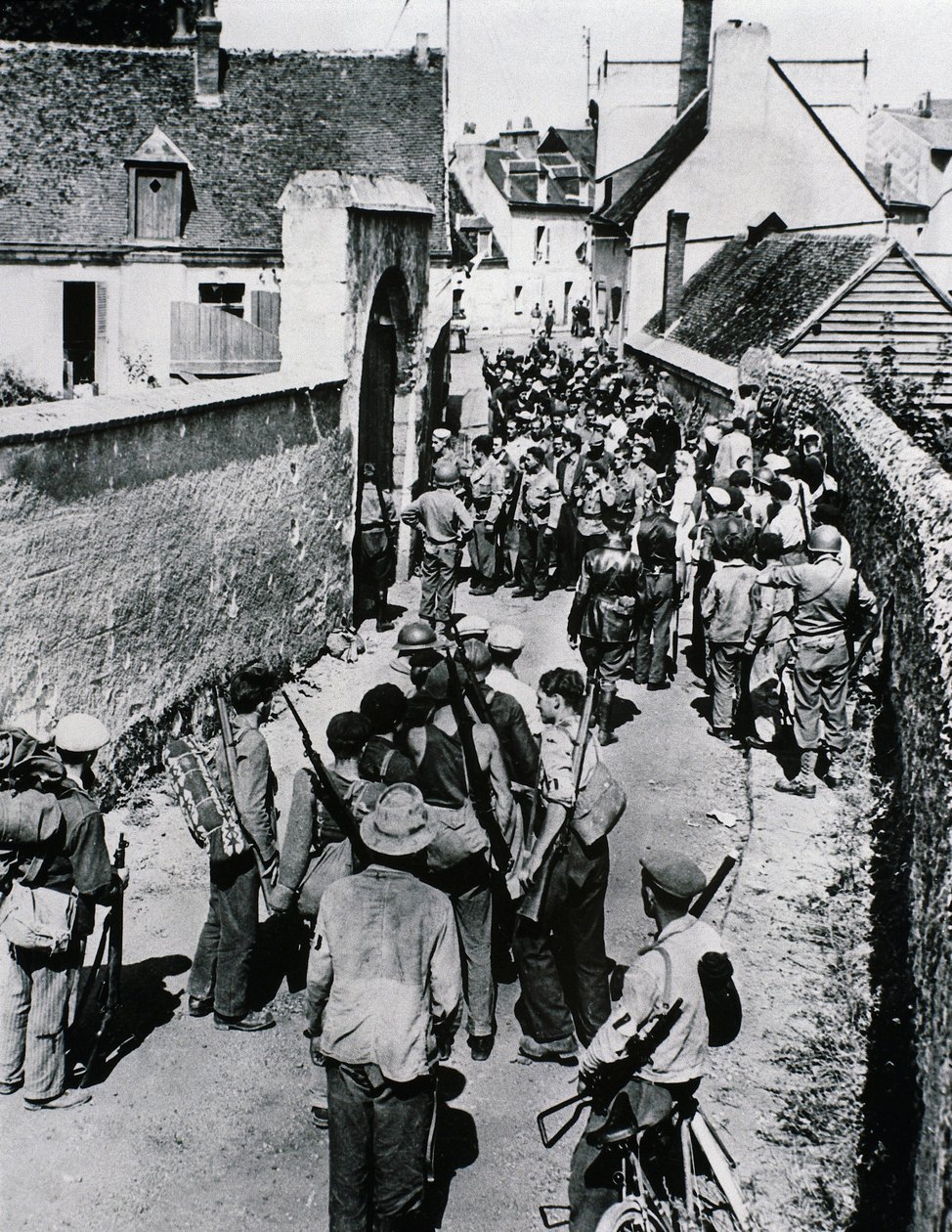 Skupiny bojovníků francouzského odporu čekají na distribuci zbraní v domě, červenec 1944 (č/b foto) od Unbekannt