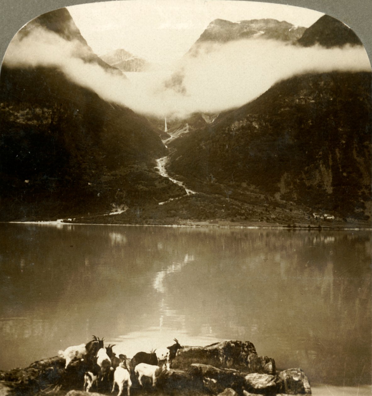 Ledovec Grytereids třpytící se nad unášenými mraky přes klidné jezero Olden, Norsko, c1905. od Unbekannt