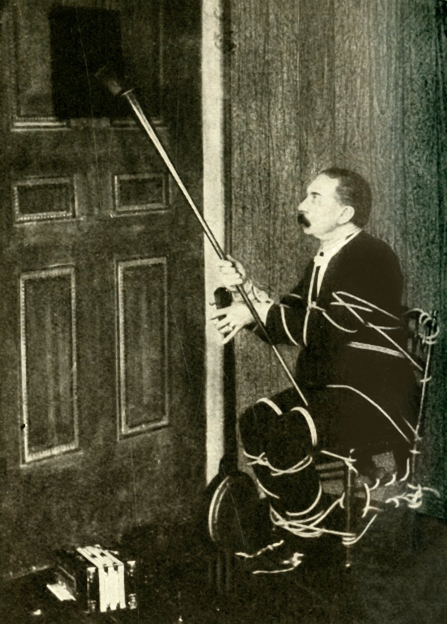 John Nevil Maskelyne provádí iluzi duchovní kabinetu, c1910. od Unbekannt