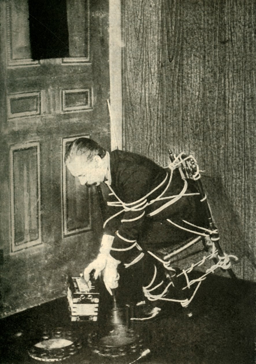 John Nevil Maskelyne provádí iluzi duchovní kabinetu, c1910. od Unbekannt