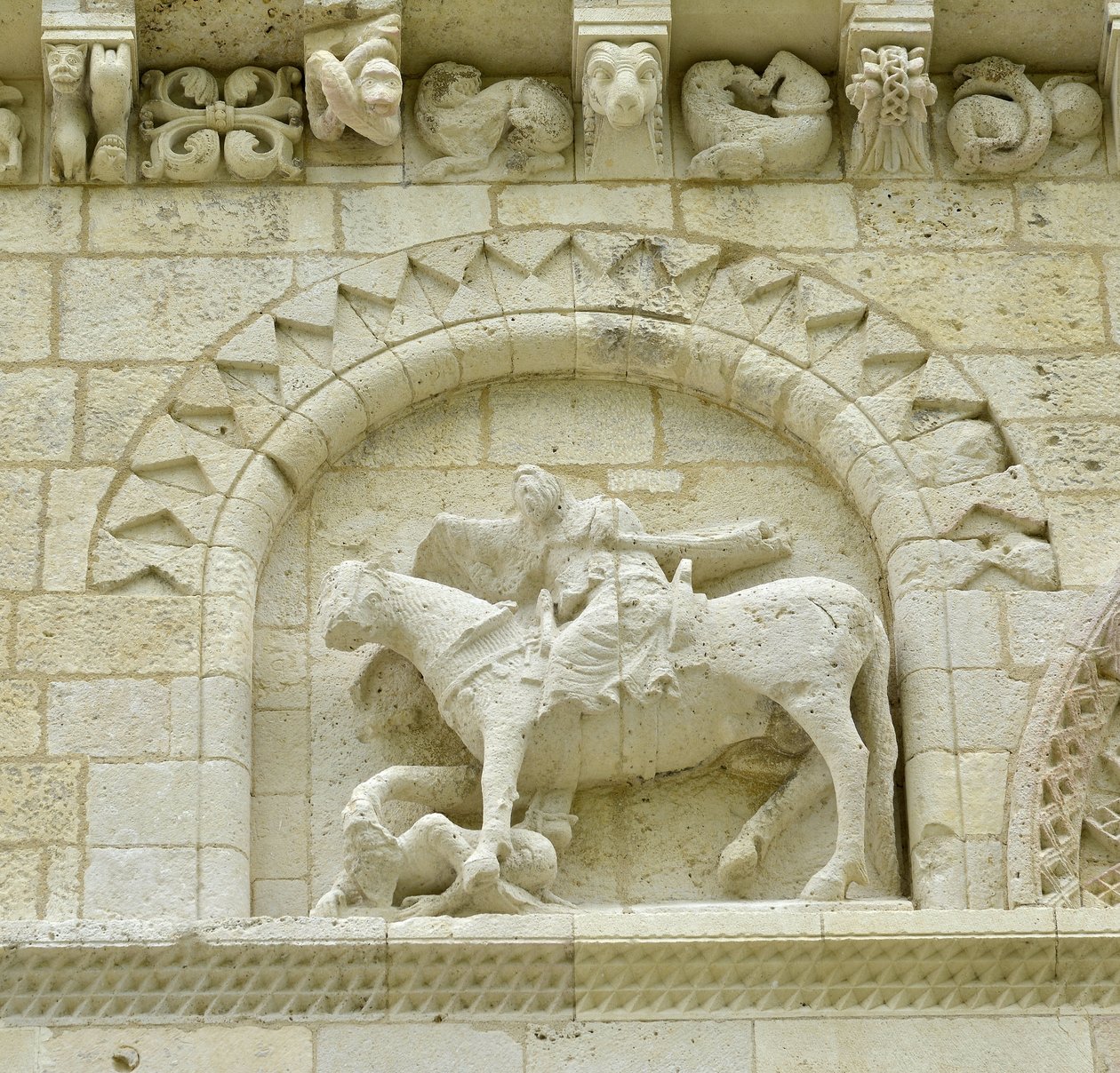 Románské umění: detail fasády zobrazující Huguese de Surgeres a Geoffroye de Vendome nebo císaře Konstantina I. Velikého, jehož noha koně šlapala Heresie a Kristus vítězící nad zlem a smrtí, Notre Dame (Notre-Dame) de Surgeres (17700) od Unbekannt