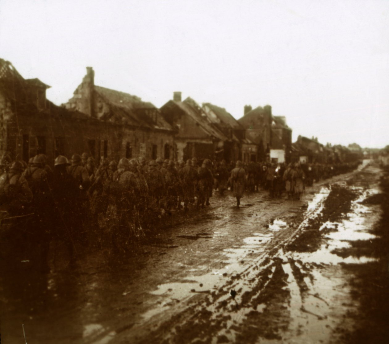 Vojáci pochodující kolem vybombardovaných domů, Champagne, severní Francie, c1914-c1918 od Unbekannt