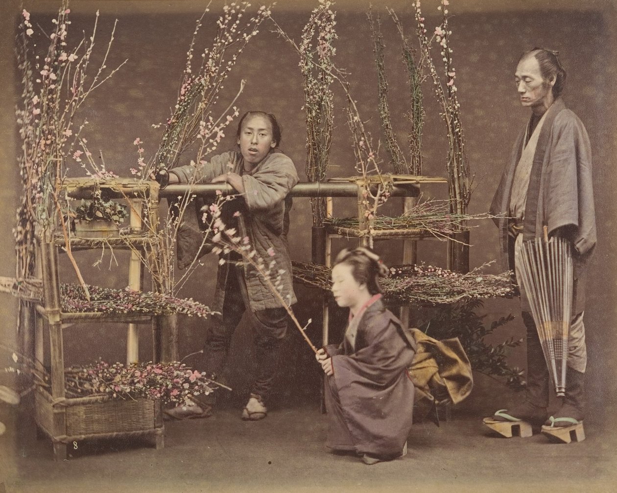 [Dva Japonci a jedna Japonka pózují s kvetoucími větvemi], 70. léta 19. století., od Unbekannt