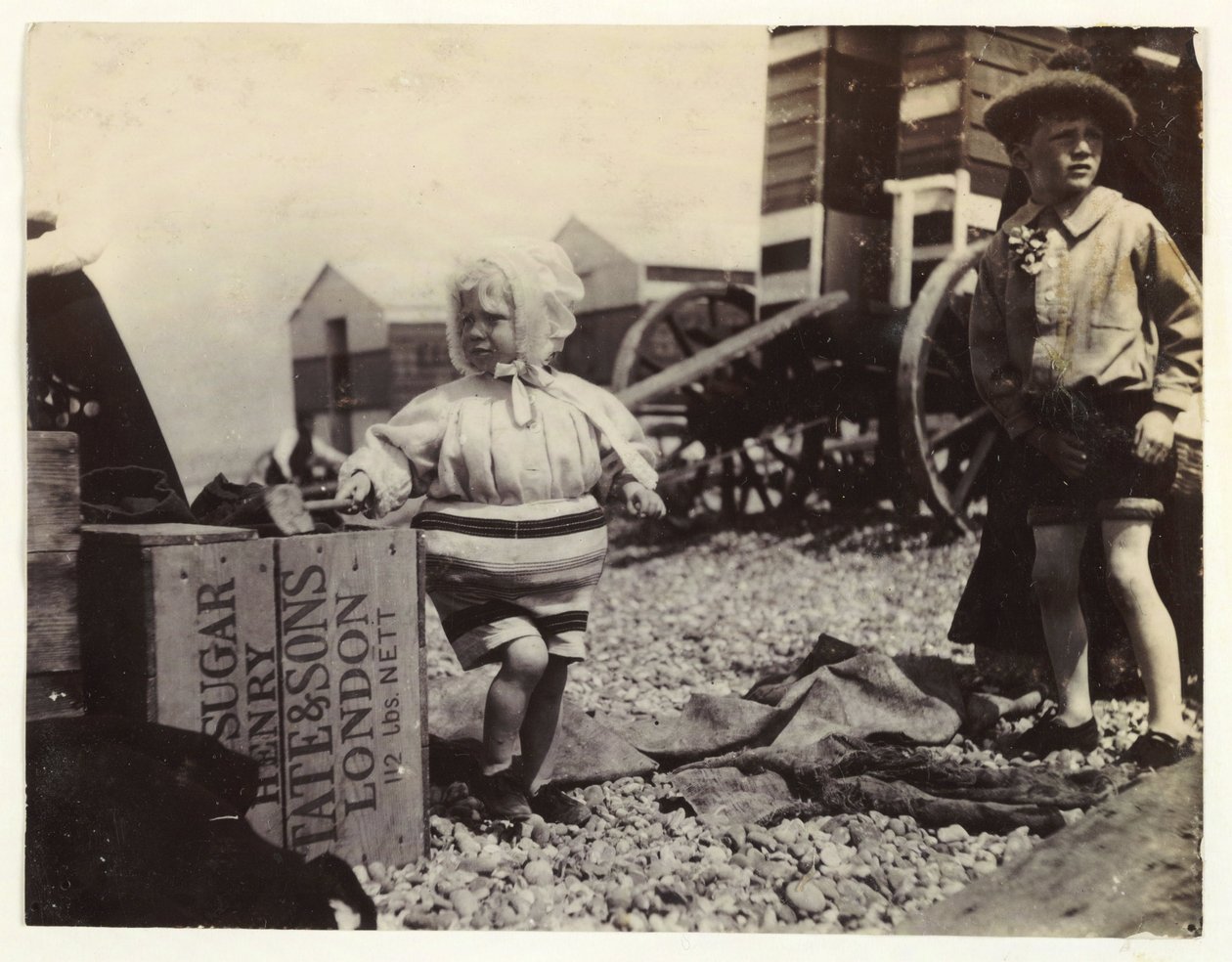 Dvě děti u koupacích strojů, c 1895, Snímek dvou dětí u moře, stojících mezi skupinou koupacích strojů na pláži od Unbekannt