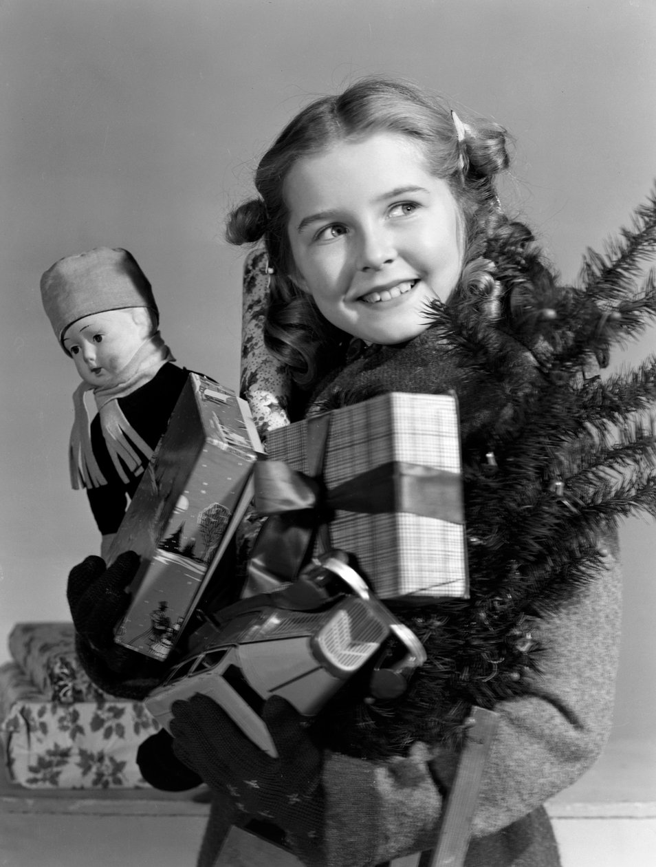 Mladá dívka nesoucí náruč vánočních dárků, c 1950 od Unbekannt