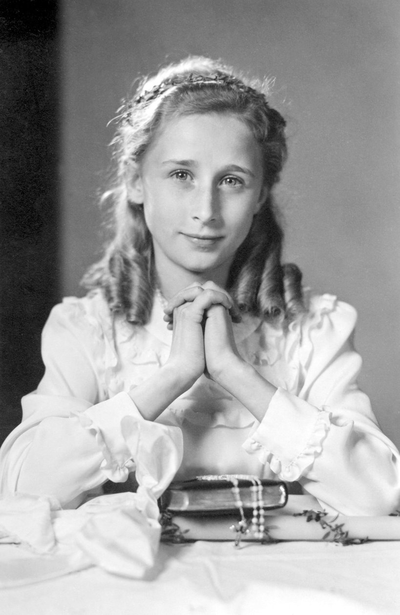 Křesťanská dívka s rukama spojenými v modlitební pozici s biblí, růžencem a svíčkou (foto přijímání). Fotografie kolem roku 1932 od Unbekannt