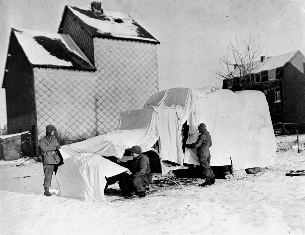Druhá světová válka (1939-1945) - Druhá světová válka (2. světová válka nebo 2. světová válka): Nedaleko Bastogne (Belgie) na konci prosince 1944: Tito američtí vojáci používají bílé plachty, aby ukryli nákladní automobil před očima nepřítele od Unbekannt