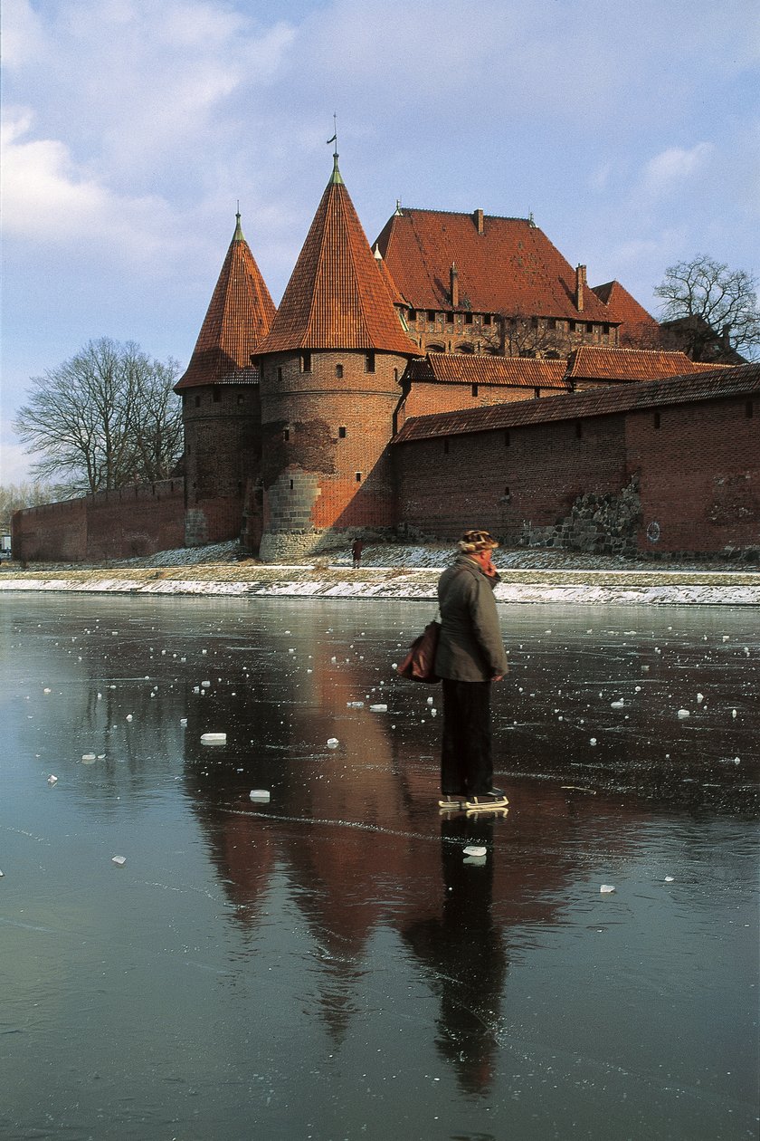 Boční profil muže stojícího na zamrzlé řece před hradem, řeka Nogat, hrad Malbork, Malbork, provincie Pomorskie, Polsko od Benjamin Baud