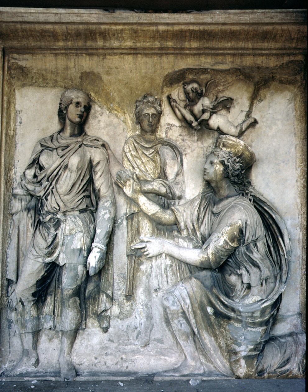 Zadní fasáda, detail starožitné reliéfní výzdoby (některé kusy z Ara Pacis z Augusta) zobrazující korunovanou bohyni a mladého muže (kámen) od Unbekannt