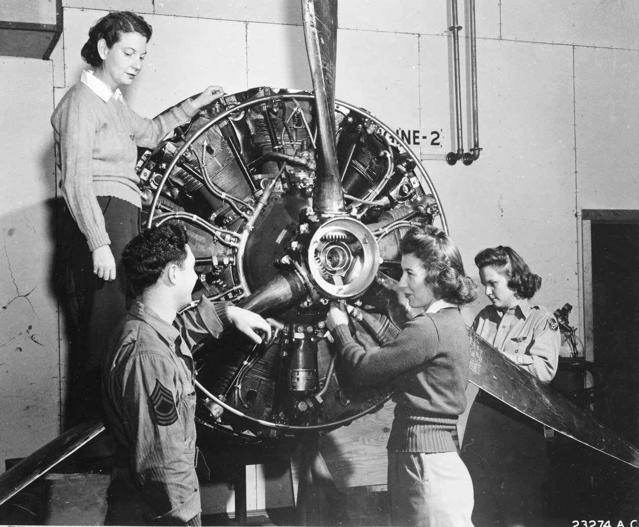 Vosy se učí, odkud se bere síla v motoru B-17 Flying Fortress, zatímco navštěvují pilotní výcvik B-17 v Lockbourne AAB, pracují na mechanismu vrtule, zatímco šéf posádky se dívá, jsou (lr): Patricia Bowser, Ann Waldner a Frances Green od Benjamin Baud