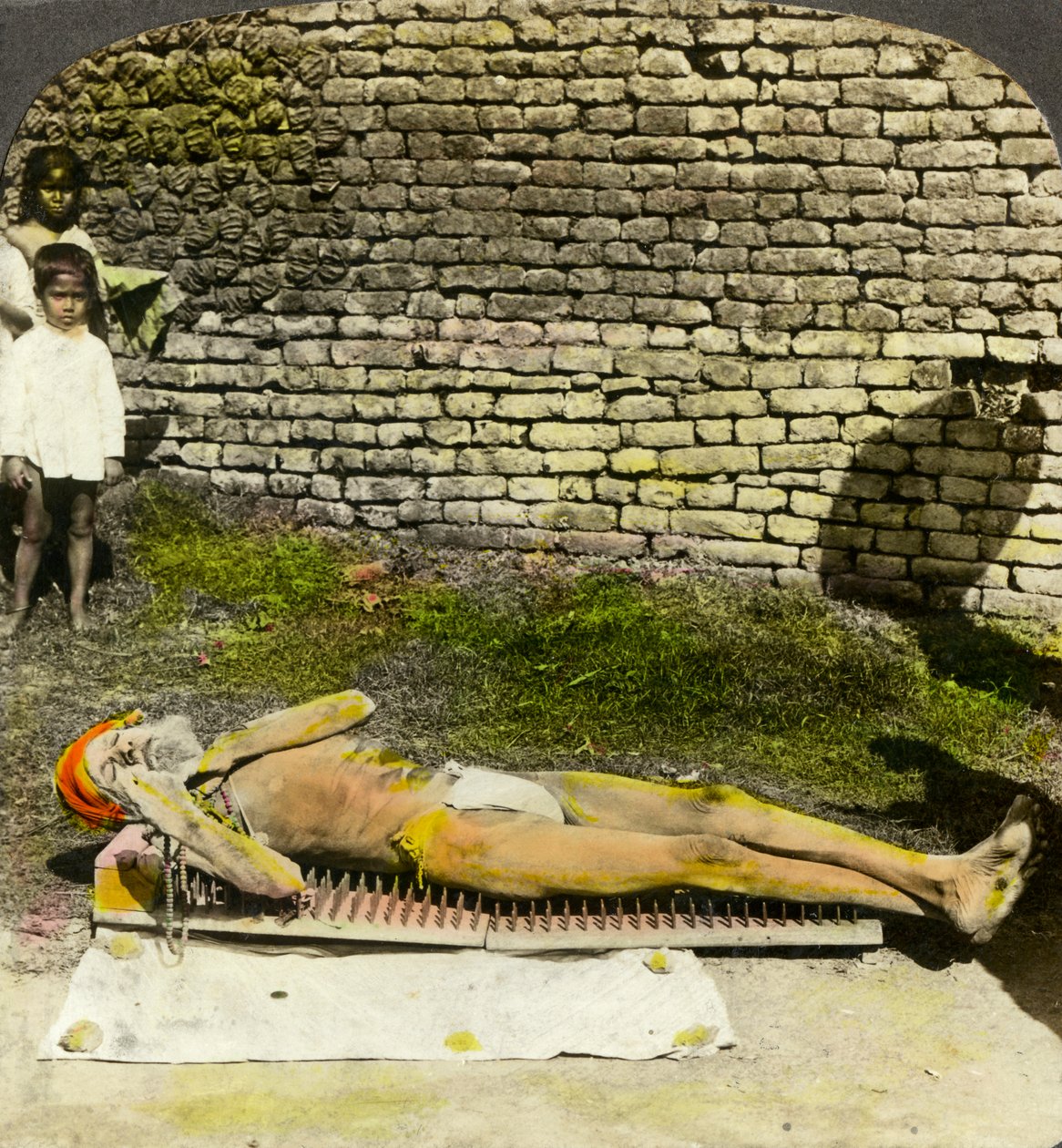 Hinduistický oddaný na hřebíkovém lůžku poblíž svatyně Kali, Kalkata, Indie, počátek 20. století od Underwood and Underwood
