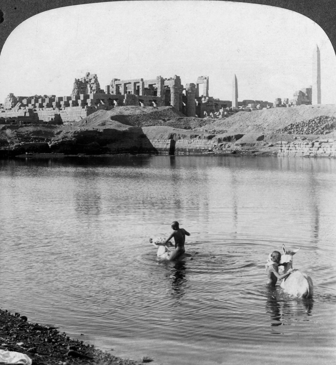 Pohled přes Posvátné jezero k velkému chrámu v Karnaku, Théby, Egypt, 1905. od Underwood and Underwood
