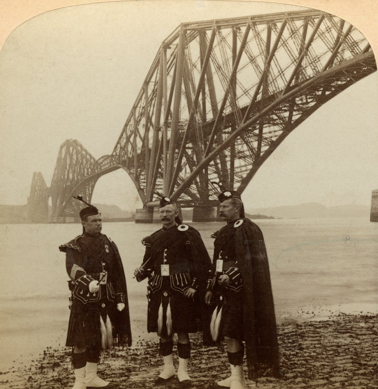 Muži v Highland se oblékají před Forth Bridge ve Skotsku. od Underwood and Underwood