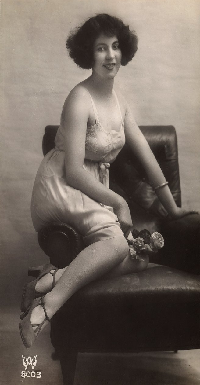 Mladá žena pózuje ve spodničce a sedí v křesle. od Unknown photographer