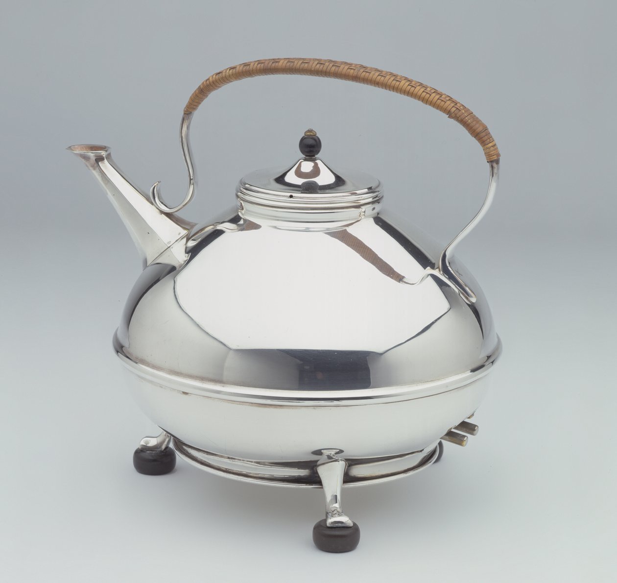 Rychlovarná konvice, c.1905 (stříbrný talíř s ebonizovanými nožičkami a knoflíkem a ratanovou rukojetí) od William Arthur Smith Benson