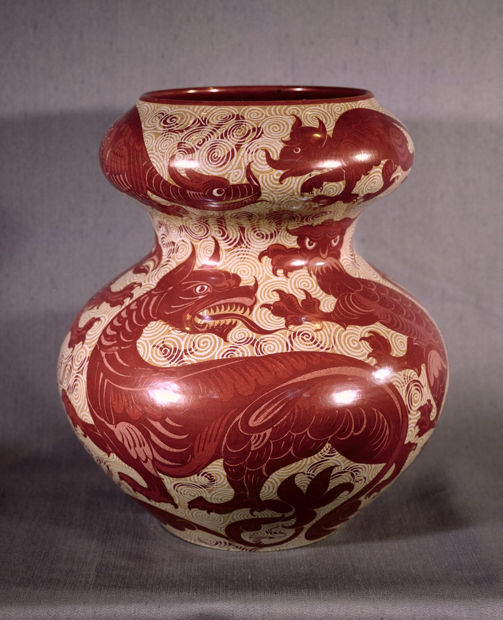 Váza zdobená motivem draků v rubínově červeném lesku na krémově zbarvené kamenině, konec 19. století (lustreware) od William de Morgan