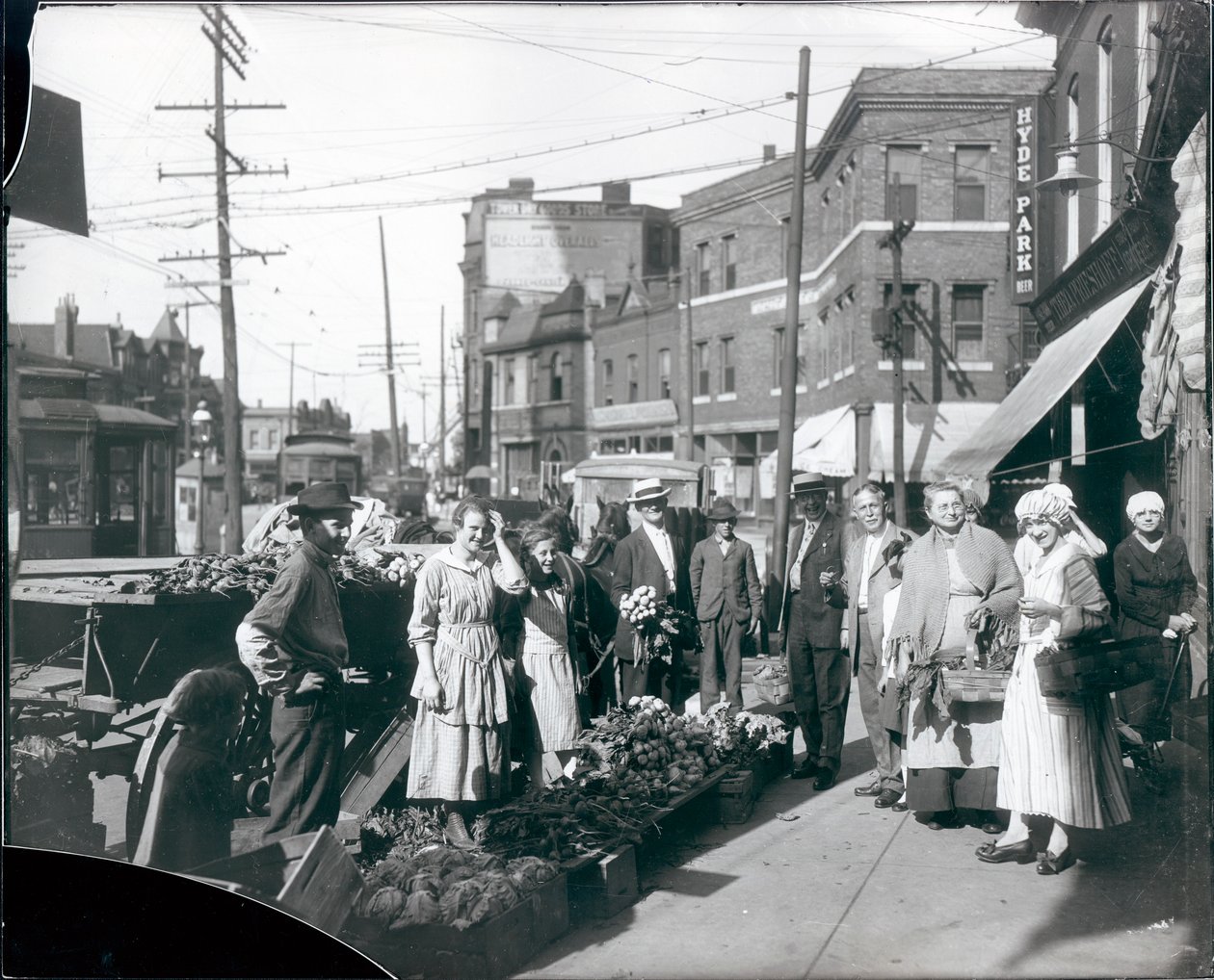 Nakupující se shromáždili u produktů na chodníku před obchodem Theodore Prieshoff Grocery, 1929 East Grand Avenue, poblíž vodárenské věže na Grand Avenue. od William G. Swekosky
