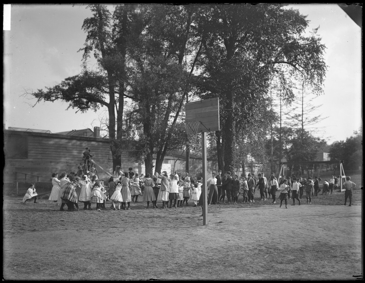 Chlapci a dívky hrající přetahovanou na neidentifikovaném hřišti, kolem roku 1910 od William Davis Hassler