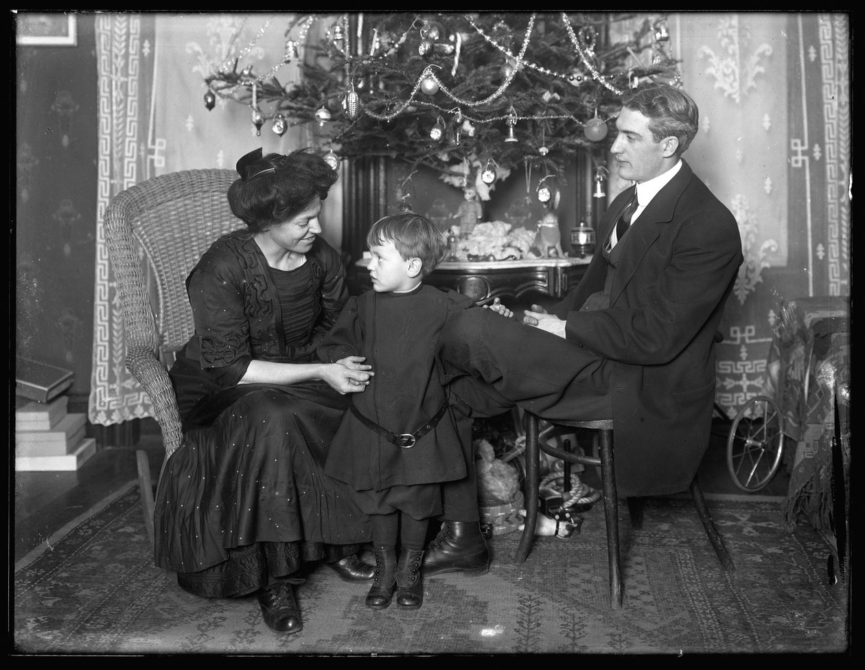 Dan Seymour s rodinou v neformální póze, sedí pod vánočním stromkem, Vánoce 1912 od William Davis Hassler