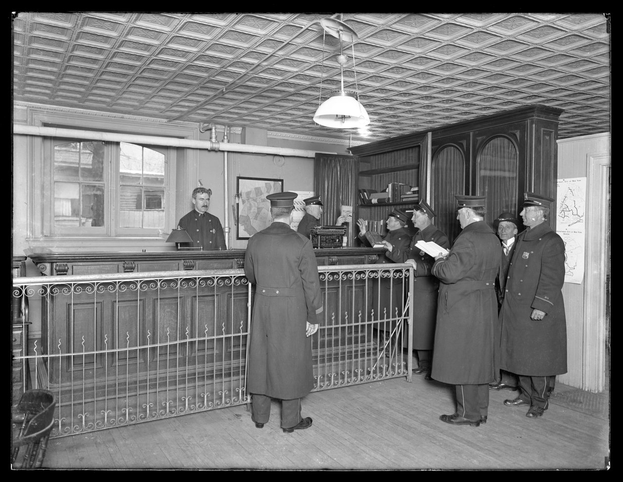 Interiér neidentifikované policejní stanice, ukazující důstojníky a recepci, c.1913-14 od William Davis Hassler