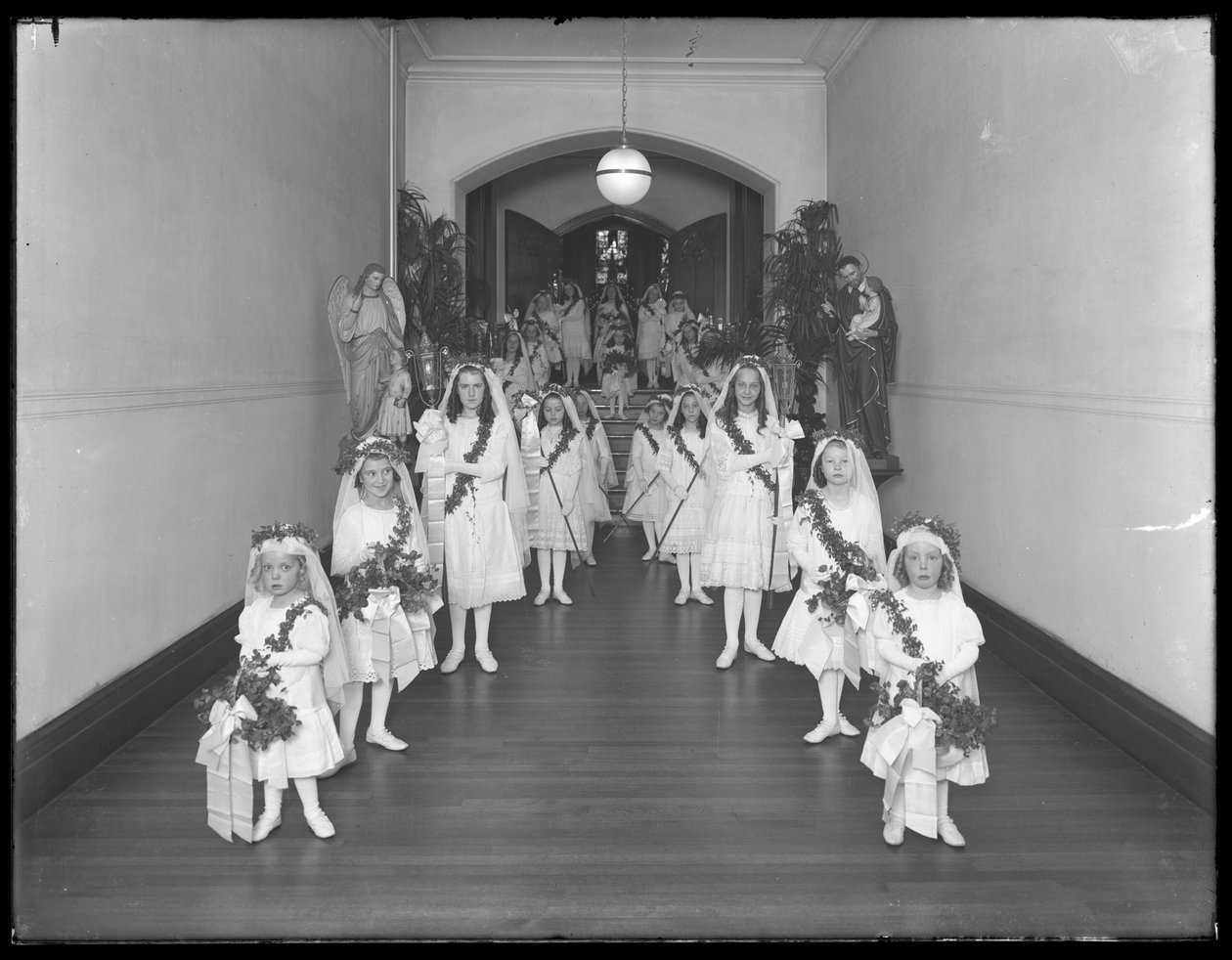 Holčičky v římskokatolickém sirotčím azylu, Kingsbridge, Bronx, vracející se z kaple v bílých šatech s věnci a girlandami, 20. října 1914 od William Davis Hassler