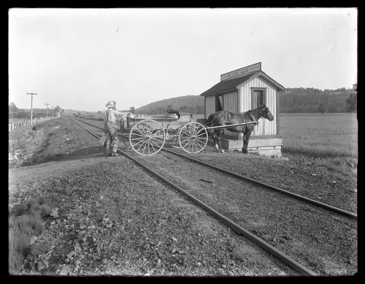Neznámý muž nakládá mléko na vozík tažený koňmi zaparkovaný nad železniční tratí před McCready farmou, Pensylvánie, kolem roku 1913 od William Davis Hassler
