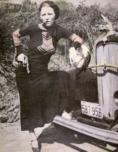 Bonnie Parker pózující „tvrdá“ se zbraní a doutníkem, kolem roku 1934 (černobílá fotografie) od American Photographer