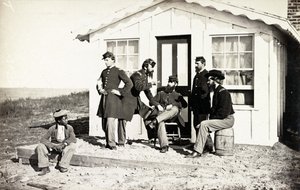 Pět vojáků občanské války se shromáždilo na hliněné verandě před domem, poblíž nich seděla afroamerická mládež, 1861-65 od American Photographer