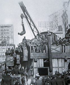 Houdini na útěku ze svěrací kazajky zavěšený na jeřábu v New Yorku (černobílá fotografie) od American Photographer