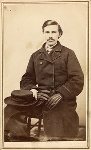 Neznámý muž v kabátu s kloboukem a rukavicemi od American Photographer