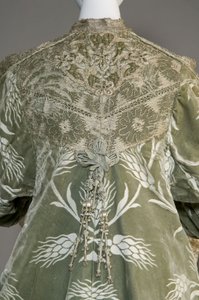 Večerní kabát Berthy Palmerové, kolem roku 1902 (detail vzadu). Hedvábný satén s broušeným sametem v pšeničném vzoru, krajka s metalickou nití, hedvábné metalické střapce. Worth, Paříž. od Charles Frederick Worth