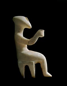 Art of the Cyclades: “”figurka sedící na stoličce””” Mramorová modla vykládaná okrovou barvou. Kykladská civilizace (-3200 a -2000) Slunce. 15,2 cm Athény, Národní archeologické muzeum (inv. 3910)