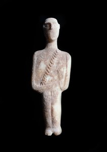 Mužský idol, schematická figurka. Socha z bílého mramoru s okrovými inkrustacemi, 3200-2000 př. Kr