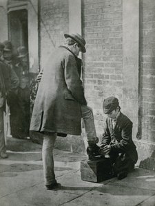 Mladý obuvník leští na ulici pánské boty od English Photographer