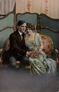 Pár drží kytici květin, sedí na loveseat. od English Photographer