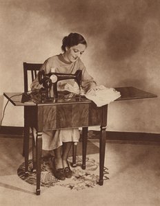 Hospodyně při práci na šicím stroji, polovina 30. let 20. století (čb fotografie) od English Photographer