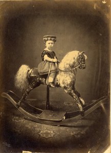 Mladá dívka sedící na houpacím koni s kapkami vody od English Photographer