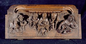 Misericord zobrazující akademika sedícího u panelového stolu, který napomíná klečícího kajícníka, New College Chapel, Oxford, konec 14. století (dřevo)