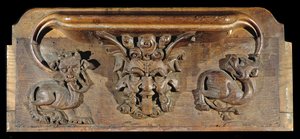 Misericord zobrazující tři lidské tváře lemované monstry, New College Chapel, Oxford, konec 14. století (dřevo)